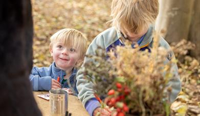 Two young boys doing crafts in the woods