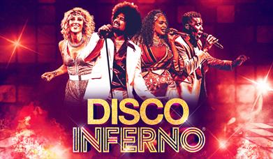 Four people singing and dancing on stage in front of Disco Inferno title in the background