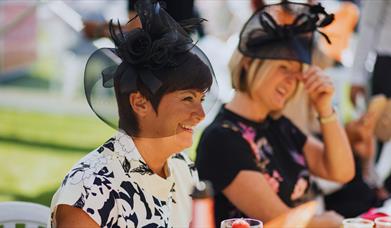 Well dressed woman with a large black fascinator.