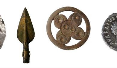 A knapped flint, arrow head, bronze broach and roman coin