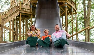 Family going down the slide at bewilderwood