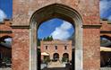 View through an archway to the courtyard with outside seating at Felbrigg Hall, Norfolk