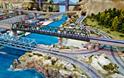 Model railway of a Japanese bullet train travelling across high speed rails from the city into the countryside.