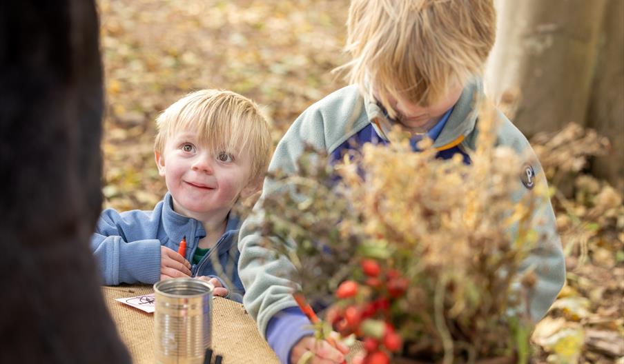 Two young boys doing crafts in the woods