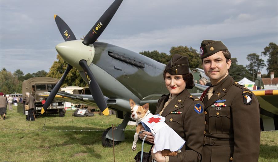 Couple in vintage dress pose in front of the Spitfire display