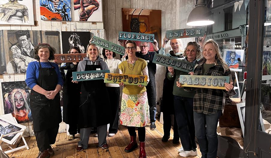 happy participants of the Make a sign workshop proudly s holding up their finished signs