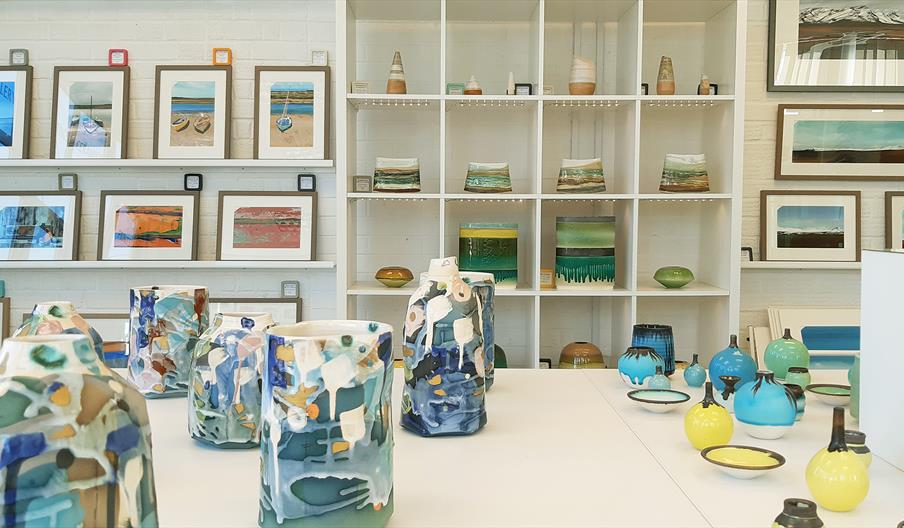 Image shows a view inside Gallery Plus, with ceramics and paintings displayed