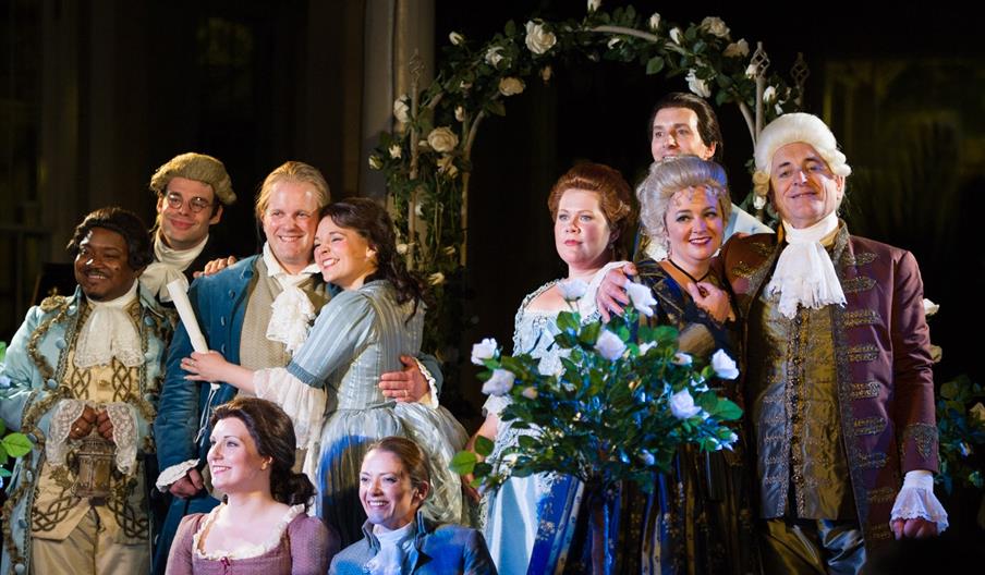 The cast of Mozart's Marriage of Figaro posed mid performance.