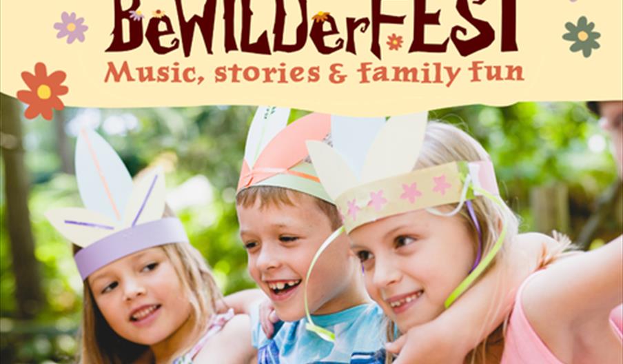 BeWILDerfest branded banner with three smiling children wearing colorful handmade paper crowns stand outdoors with their arms around each other in a s