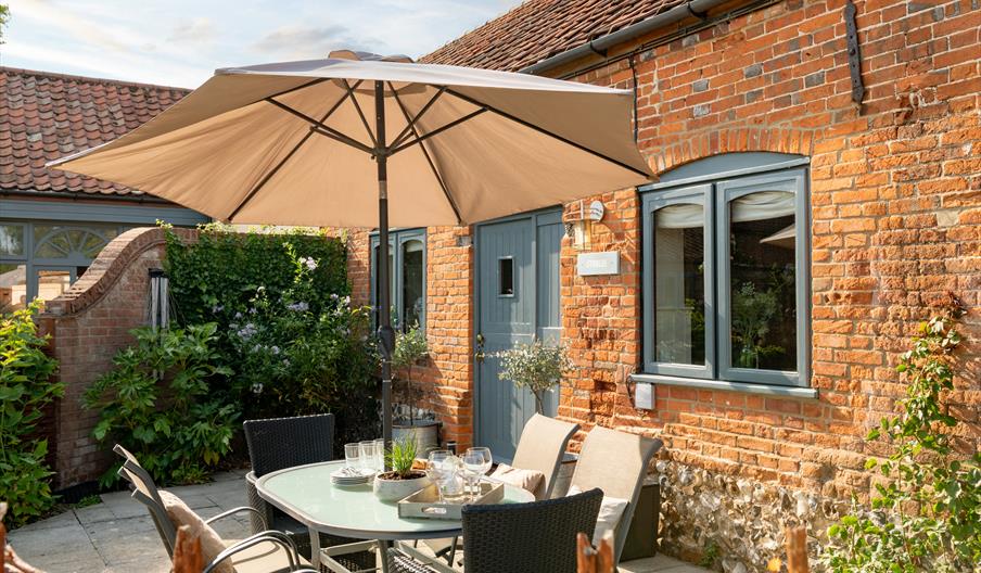 The Stables Patio. With table and sun shade. Tunstead Cottages