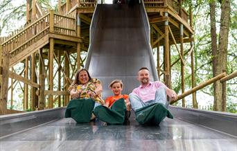 Family going down the slide at bewilderwood