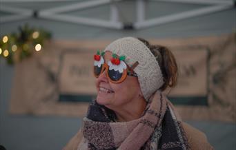 Holt Sunday Market trader in fun Christmas sunglasses