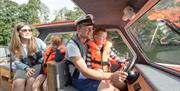 Dad steering a day boat in the Broads National Park