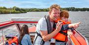 Young girl on a Day Boat spotting wildlife on the Broads National Park