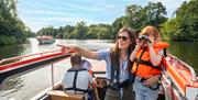 Young girl with binoculars on a Day Boat exploring the Broads National Park