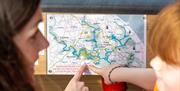 Mum and daughter route planning a day out on a day boat in the Broads National Park