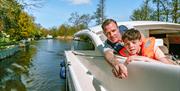 Dad and son spotting wildlife on a Cruiser in the Broads National Park