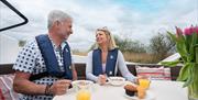 Couple enjoying breakfast on a Cruiser in the Broads National Park