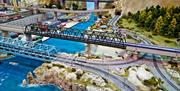 Model railway of a Japanese bullet train travelling across high speed rails from the city into the countryside.