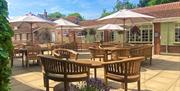 Blue sky, patio tables and chairs with parasols.