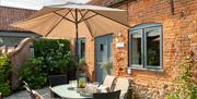 The Stables Patio. With table and sun shade. Tunstead Cottages