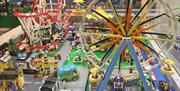 Miniature bricks making up a fun fair with rollercoaster and ferris wheel. All the fu of the fairground.