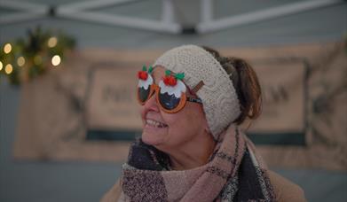 Holt Sunday Market trader in fun Christmas sunglasses