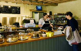 A customer and member of staff in the Muddy Boots café at Blickling Estate, Norfolk