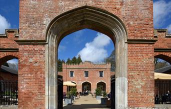 View through an archway to the courtyard with outside seating at Felbrigg Hall, Norfolk