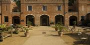 A view across the courtyard which now houses the plant sales area and outside seating for the Squire's Pantry tea room at Felbrigg Hall, Norfolk