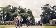 Group cycling e-bikes through Norfolk countryside.