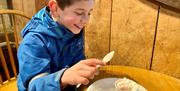 A child enjoys a hot chocolate at the Muddy Boots Café, Blickling Norfolk