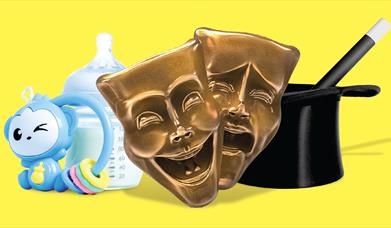 A baby's bottle and rattle and magicians hat and wand sit alongside comedy and tragegy drama masks - a twisted trio of objects