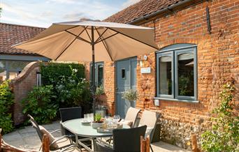 The Stables Patio. With table and sun shade. Tunstead Cottages