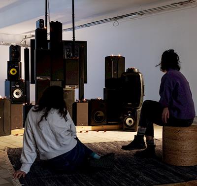 two people in front of speakers