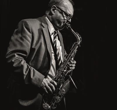 Black and white photo of Alan Barnes playing a saxophone