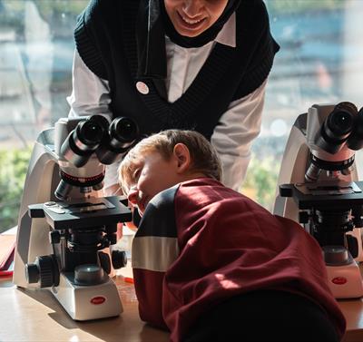 A child looking at a microscope