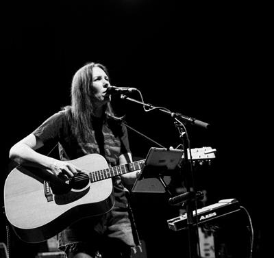 Black and white photo of Thea Gilmore on stage with a guitar