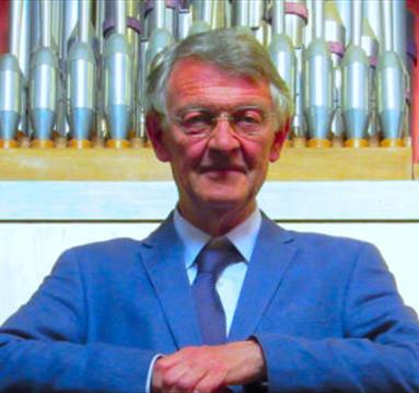 man in front of an organ
