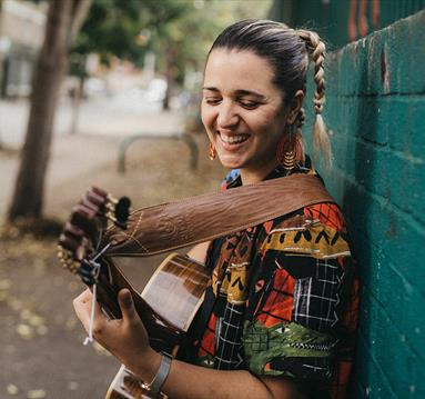 woman smiling playing guitar