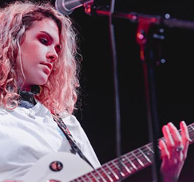 woman playing electric guitar