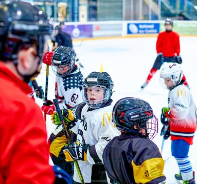 Photo of a coach with young ice hockey students