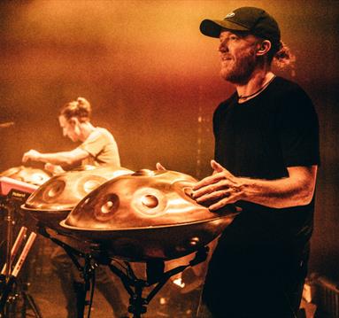 Photo of Hang Massive on stage performing with steel drums
