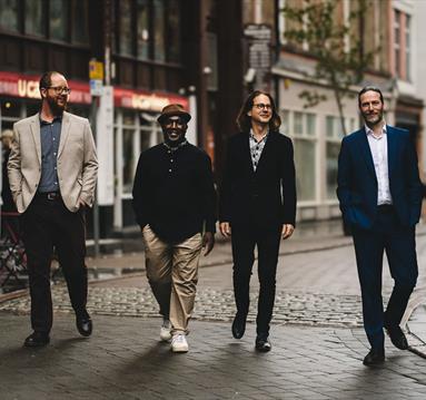 Photo of Sharp Little Bones ft Tony Kofi walking down a street