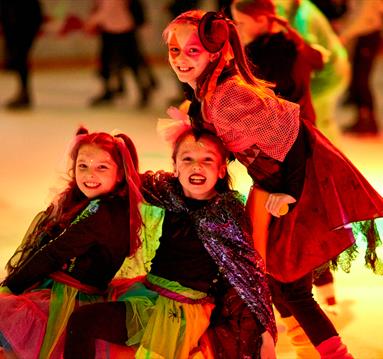 Photo of kids in fancy dress skating on the ice