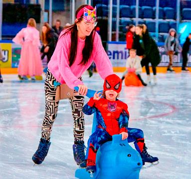 Photo of a mum and young son dressed as spiderman enjoying an ice-skating session using ice equipment.