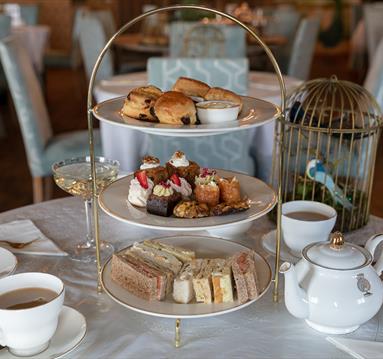 A photograph of an Afternoon Tea tower on an ornately dressed tabletop
