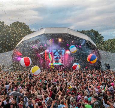 Photo of a music festival facing the stage. In the foreground you can see a large crowd