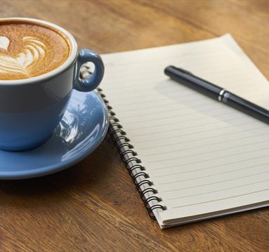 Photo of a blank notepad and a latte