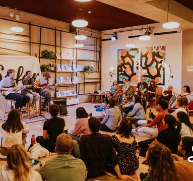 A trio of musicians play to a seated audience